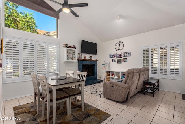 interior space with a fireplace, high vaulted ceiling, a wealth of natural light, and light tile patterned flooring