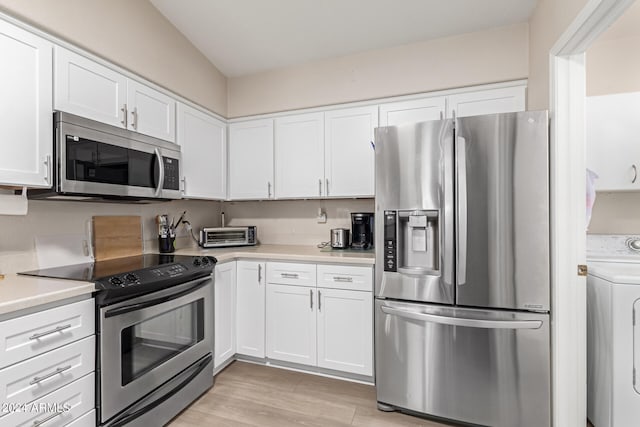 kitchen featuring washer / clothes dryer, stainless steel appliances, white cabinetry, and light hardwood / wood-style flooring