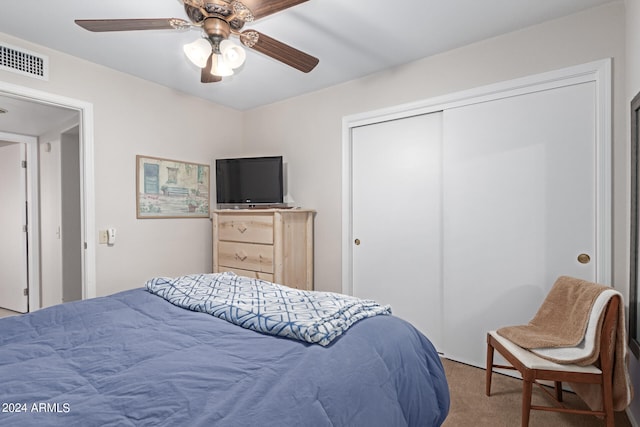 carpeted bedroom with ceiling fan and a closet