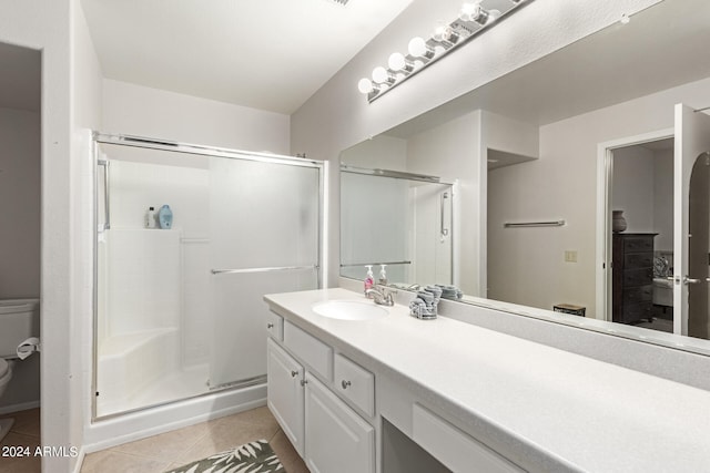 bathroom featuring vanity, toilet, walk in shower, and tile patterned flooring