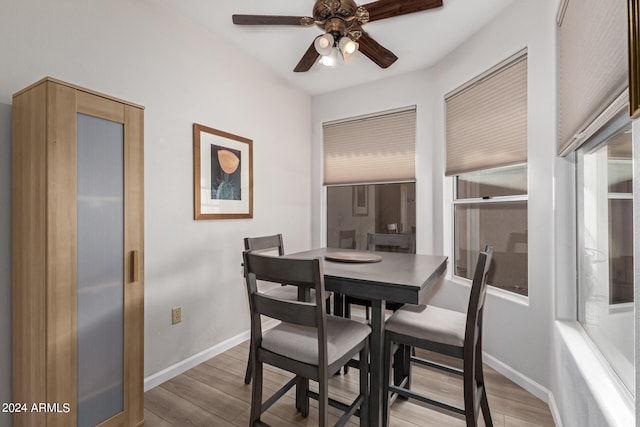 dining area with light wood-type flooring and ceiling fan