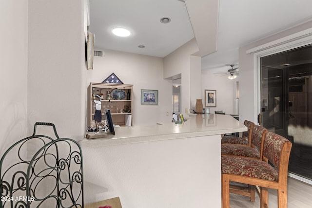 kitchen featuring ceiling fan, hardwood / wood-style flooring, and kitchen peninsula