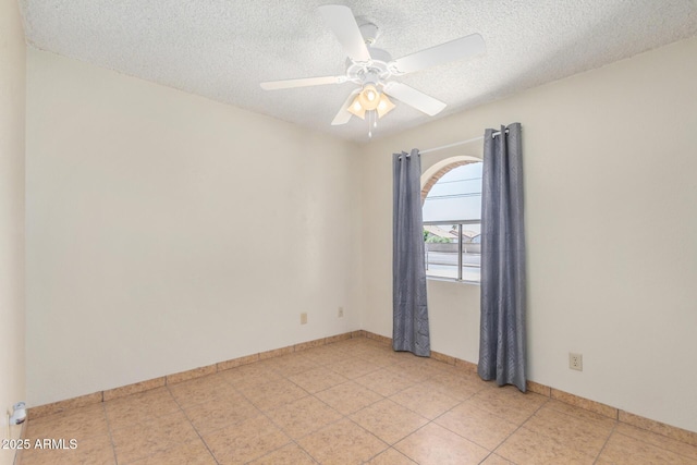 6430 W Thomas Rd, Phoenix, AZ 85033 - empty room with a textured ceiling, light tile patterned flooring, ceiling fan, and baseboards