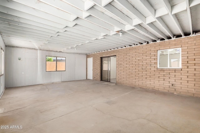 6430 W Thomas Rd, Phoenix, AZ 85033 - spare room with unfinished concrete flooring and brick wall