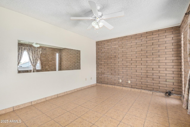 6430 W Thomas Rd, Phoenix, AZ 85033 - empty room featuring a textured ceiling, brick wall, and ceiling fan