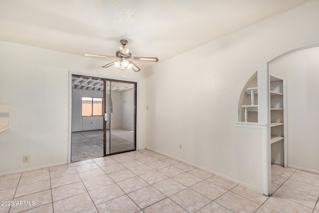 6430 W Thomas Rd, Phoenix, AZ 85033 - unfurnished room featuring a ceiling fan, arched walkways, light tile patterned floors, and baseboards