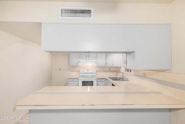 6430 W Thomas Rd, Phoenix, AZ 85033 - kitchen featuring electric range, a sink, light countertops, a peninsula, and decorative backsplash