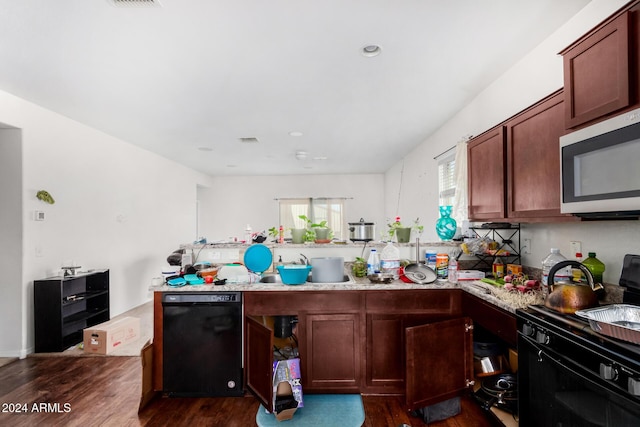 kitchen with kitchen peninsula, dark hardwood / wood-style floors, and black dishwasher