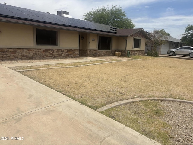 5542 W Monte Cristo Ave, Glendale, AZ 85306 - view of front of home with stone siding, stucco siding, roof mounted solar panels, and roof with shingles