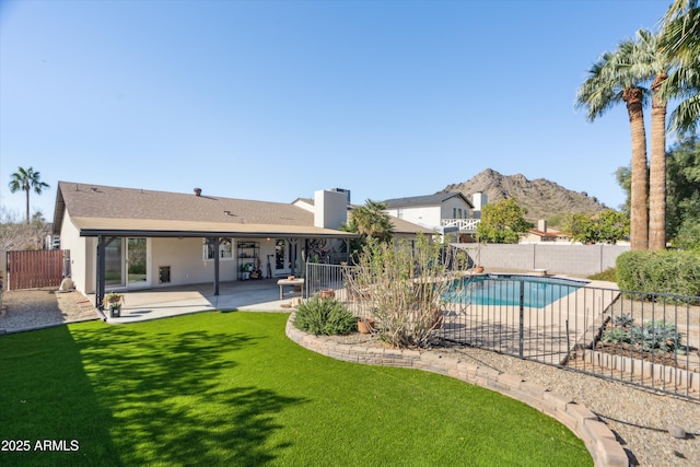 view of pool featuring a fenced in pool, a yard, a fenced backyard, a patio area, and a mountain view