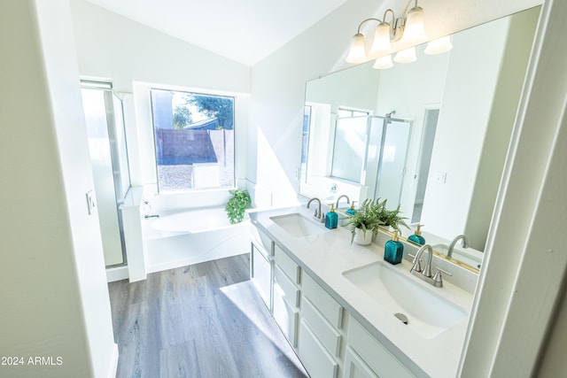 bathroom with separate shower and tub, vanity, wood-type flooring, and vaulted ceiling