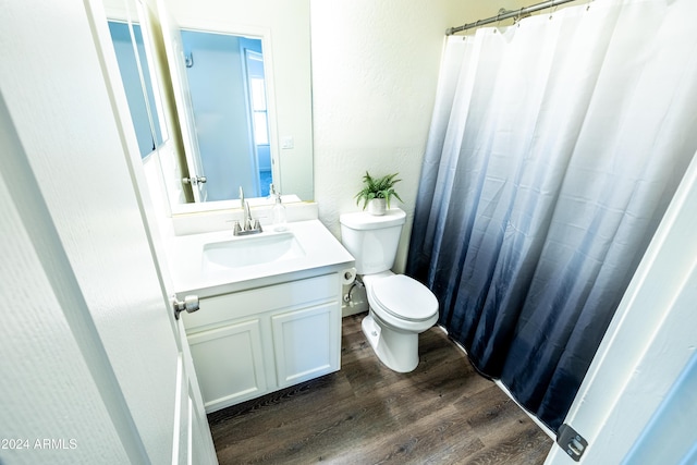 bathroom with wood-type flooring, vanity, and toilet