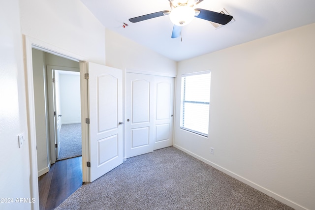 unfurnished bedroom featuring ceiling fan, a closet, carpet floors, and vaulted ceiling