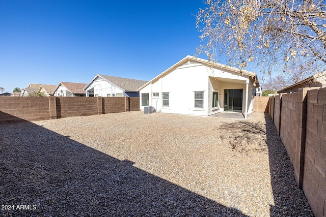 rear view of house featuring cooling unit and a patio