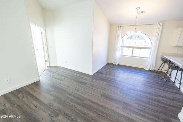 unfurnished dining area featuring a chandelier and dark wood-type flooring