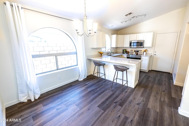 kitchen featuring kitchen peninsula, stainless steel appliances, vaulted ceiling, sink, and white cabinets