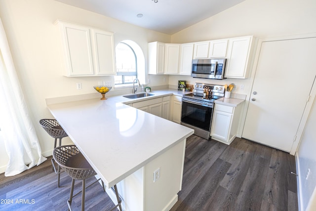 kitchen with kitchen peninsula, stainless steel appliances, white cabinetry, and lofted ceiling