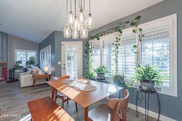 dining space featuring lofted ceiling, a notable chandelier, and hardwood / wood-style floors