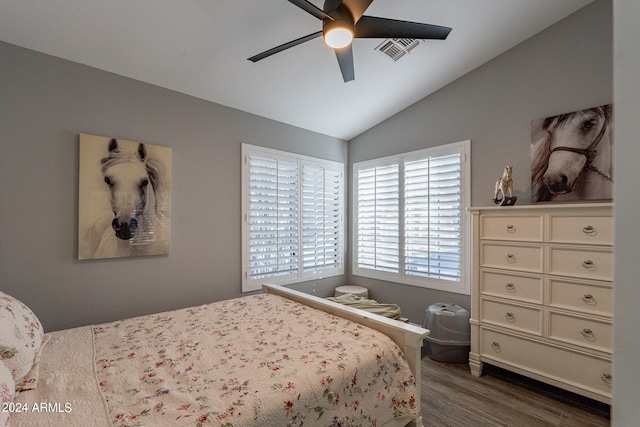 bedroom with ceiling fan, lofted ceiling, and dark hardwood / wood-style floors