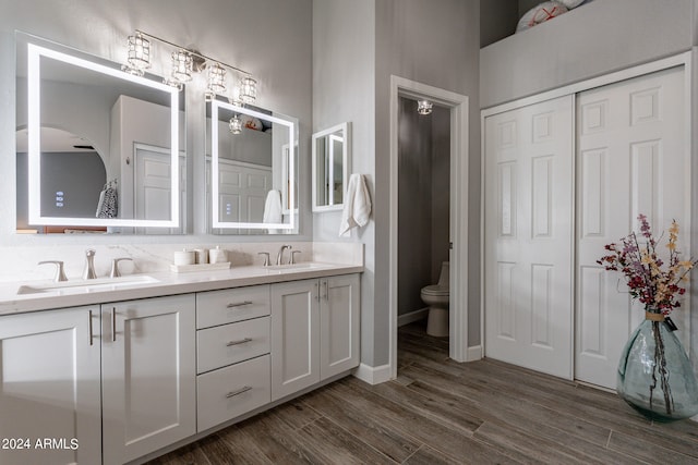 bathroom with hardwood / wood-style floors, vanity, and toilet