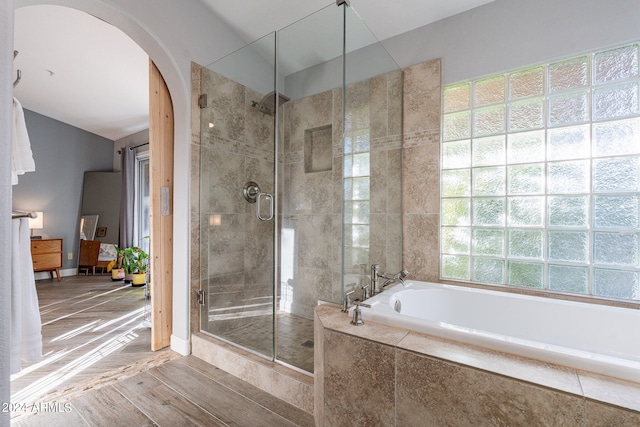 bathroom featuring hardwood / wood-style flooring and plus walk in shower