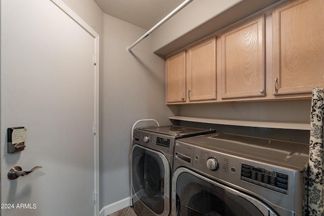 laundry area featuring separate washer and dryer and cabinets