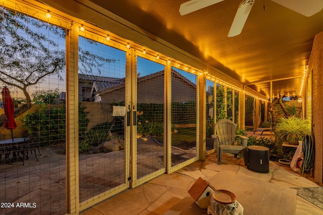 unfurnished sunroom featuring ceiling fan