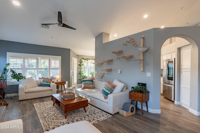 living room featuring ceiling fan and dark wood-type flooring