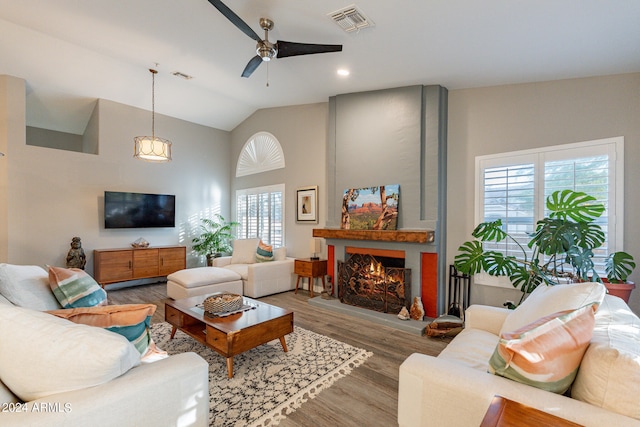 living room with a large fireplace, hardwood / wood-style flooring, a wealth of natural light, and ceiling fan