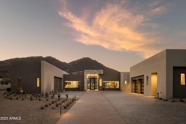 adobe home featuring a mountain view and a garage