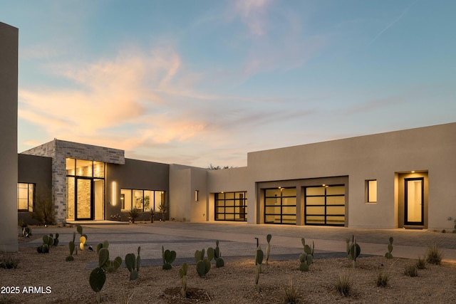 back house at dusk with a garage