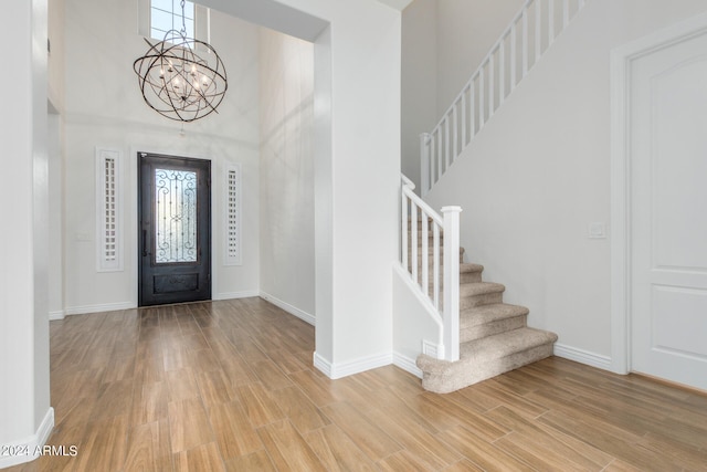 foyer entrance with a notable chandelier, a high ceiling, and light hardwood / wood-style floors