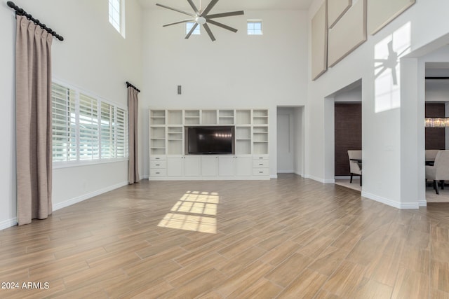 unfurnished living room with a wealth of natural light, light hardwood / wood-style floors, and ceiling fan