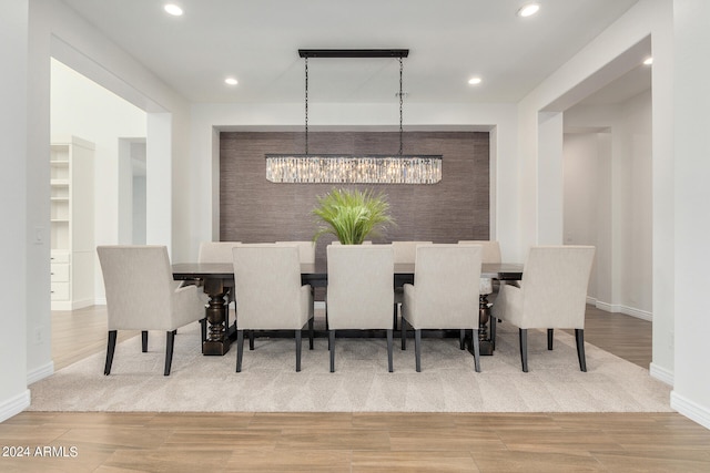 dining area featuring wood-type flooring and a notable chandelier