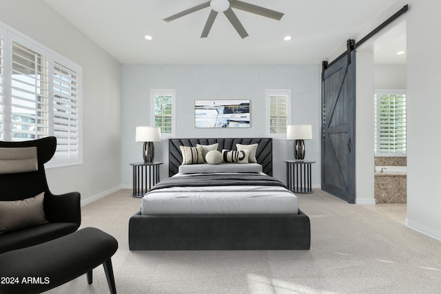 carpeted bedroom featuring connected bathroom, ceiling fan, and a barn door