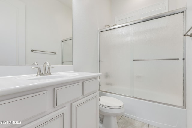 full bathroom featuring enclosed tub / shower combo, vanity, toilet, and tile patterned floors