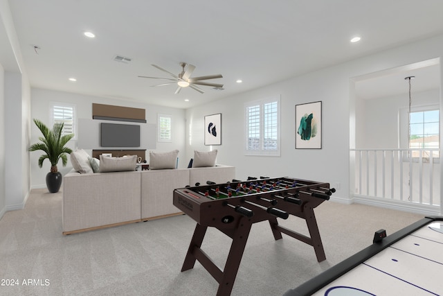 recreation room featuring ceiling fan, light colored carpet, and a wealth of natural light