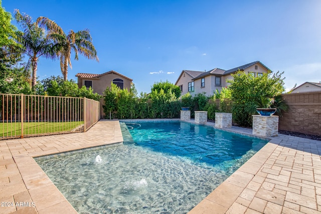 view of swimming pool with pool water feature and a patio