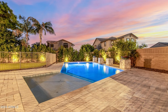 pool at dusk with a patio