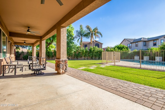 view of patio featuring ceiling fan and a fenced in pool