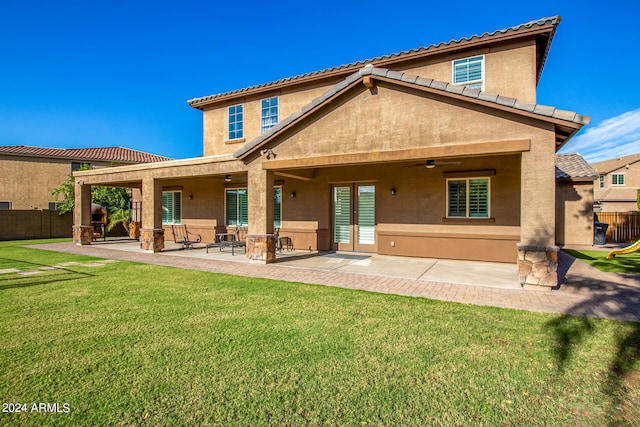 back of house featuring a patio, a lawn, and ceiling fan