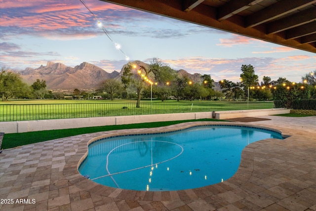 pool at dusk with a mountain view and a patio