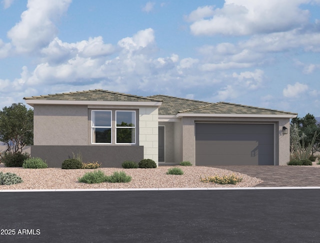 prairie-style house featuring an attached garage, driveway, and stucco siding
