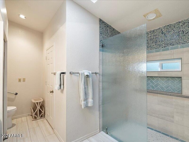 bathroom featuring toilet and tiled shower