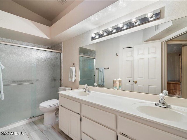 bathroom with walk in shower, vanity, and toilet