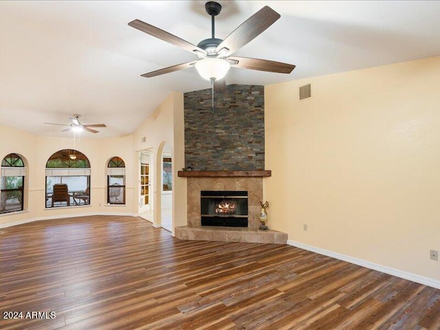 unfurnished living room featuring a fireplace, dark wood-type flooring, ceiling fan, and vaulted ceiling