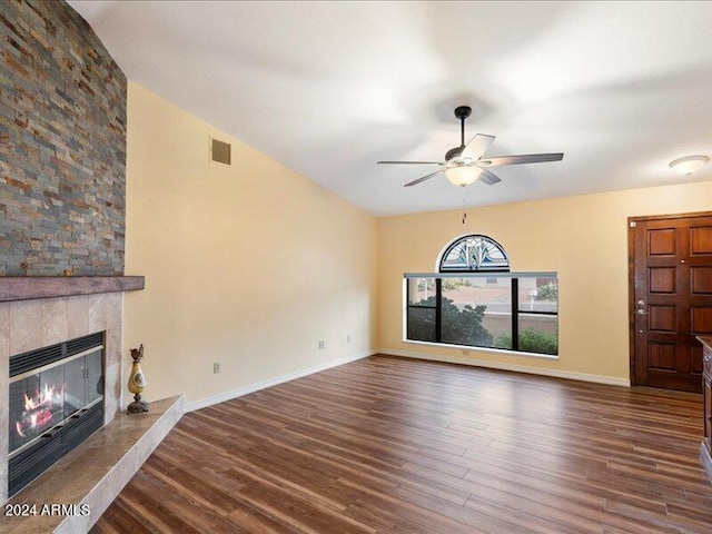 unfurnished living room featuring a tiled fireplace, ceiling fan, and dark hardwood / wood-style floors