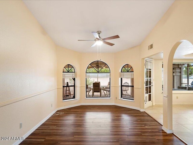 unfurnished room featuring a wealth of natural light, hardwood / wood-style flooring, and ceiling fan