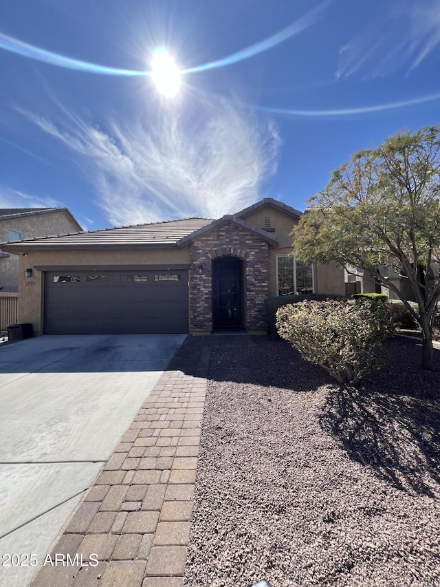 ranch-style house featuring a garage, driveway, a tiled roof, and stucco siding