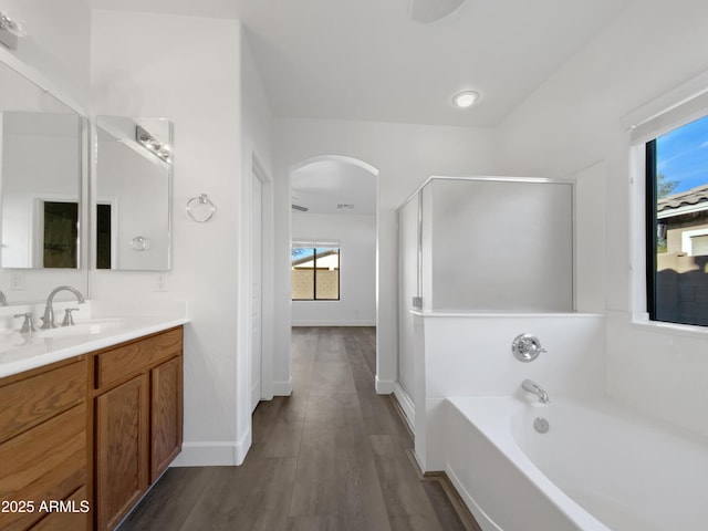 bathroom featuring hardwood / wood-style flooring, vanity, and plus walk in shower